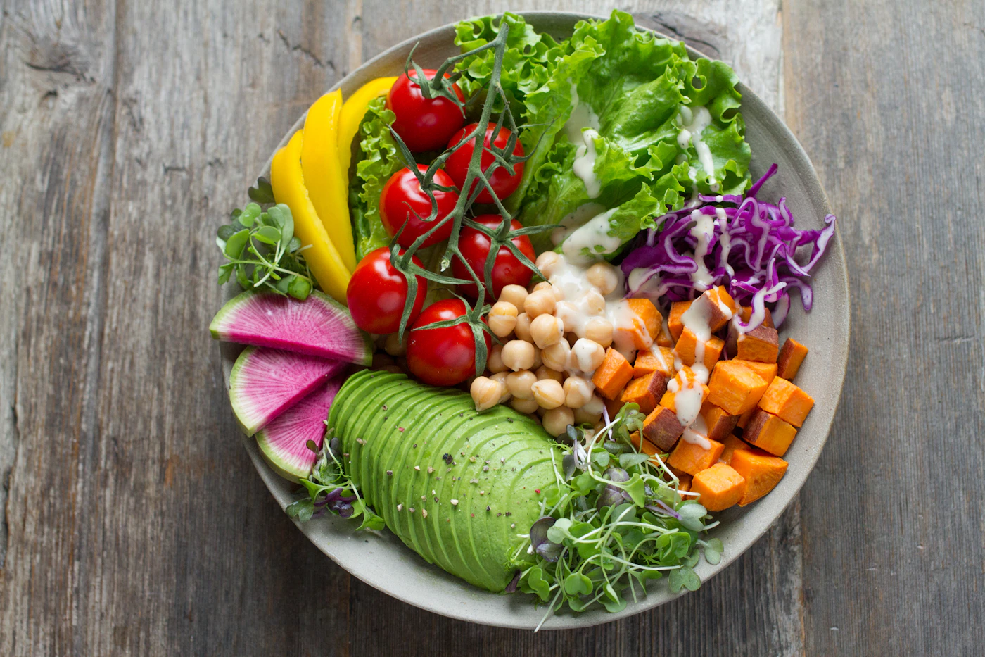 Una bowl di ceci, avocado e verdure colorate